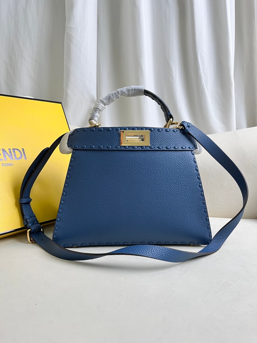 FENDI PeekabooISeeU: The blue FENDI Peekaboo SeeU medium handbag is crafted from pebbled calfskin, featuring classic twist locks on both sides, a soft Nappa leather lining, two compartments separated by a rigid divider,