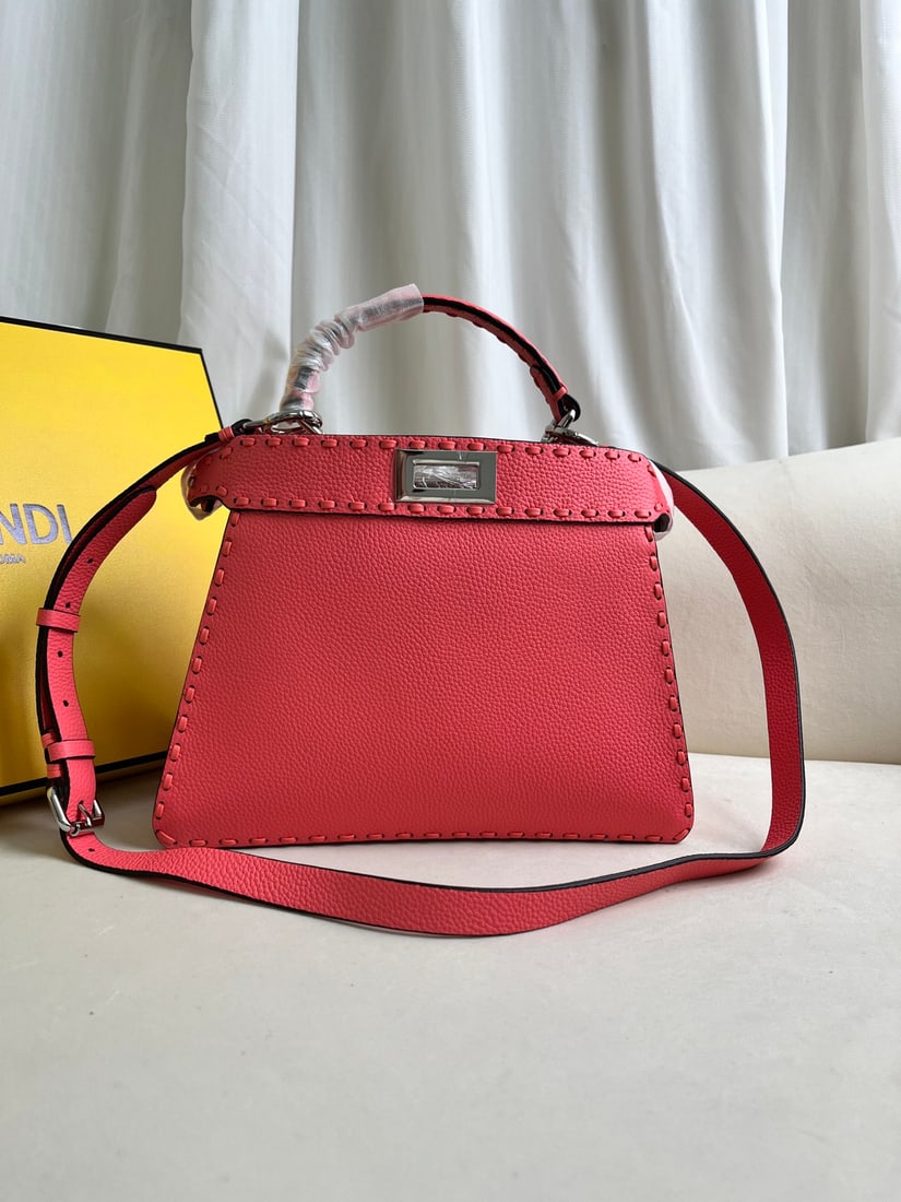 FENDI PeekabooISeeU: This pink FENDI Peekaboo I SeeU medium-sized handbag is crafted from pebbled calfskin leather, featuring classic twist locks on both sides, a soft Nappa leather lining, two compartments separated by