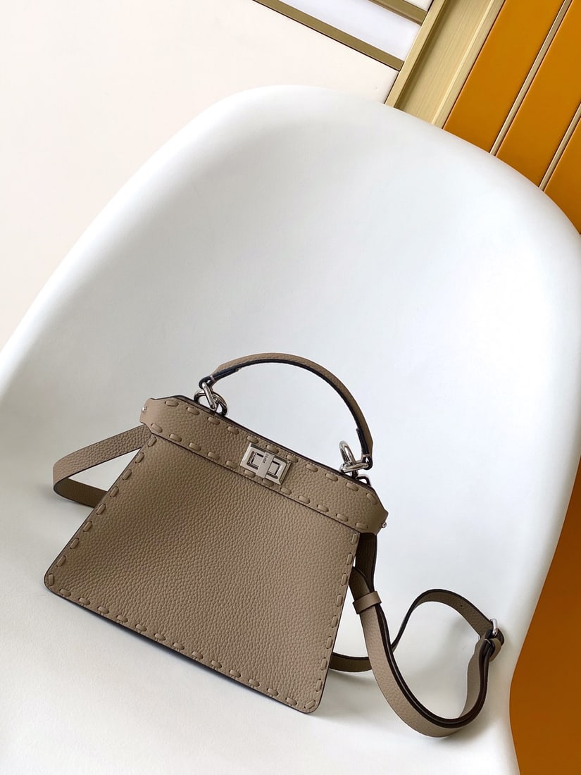 Fendi conic Peekaboo ISeeU Mini: Fendi conic Peekaboo ISeeU Mini is made of calfskin leather, with large, tonal stitching and hand-stitched details. It features a classic twist lock, two compartments, a handle, and an adjustable,