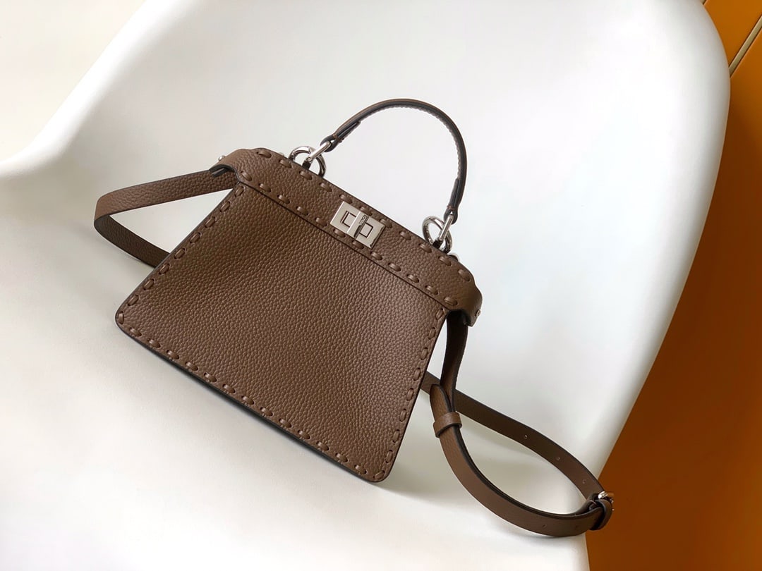 Fendi conic Peekaboo ISeeU Mini: Fendi conic Peekaboo ISeeU Mini is made of calfskin leather, with large, tonal stitching and hand-stitched details. It features a classic twist lock, two compartments, a handle, and an adjustable,