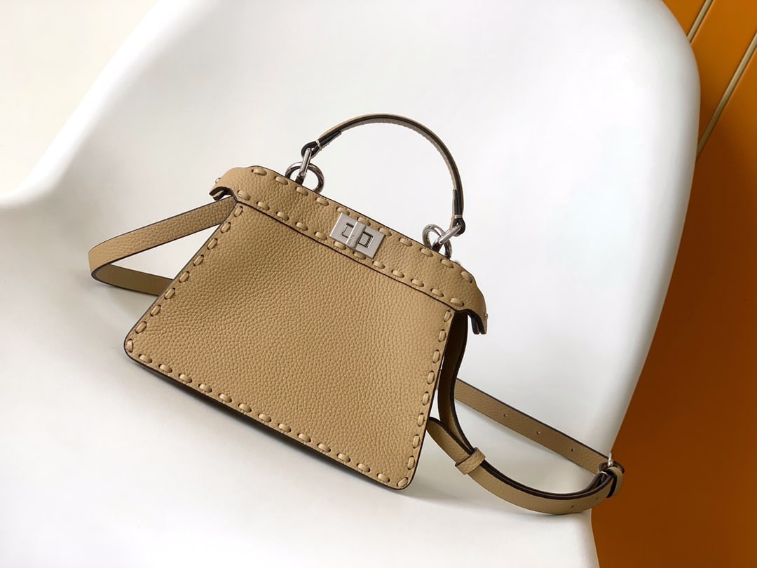 Fendi conic Peekaboo ISeeU Mini: Fendi conic Peekaboo ISeeU Mini is made of calfskin leather, with large, tonal stitching and hand-stitched details. It features a classic twist lock, two compartments, a handle, and an adjustable, det