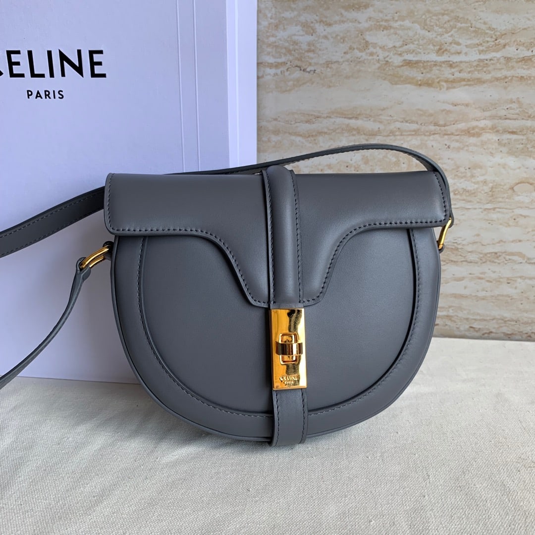 Celine: This grey plain-weave BESACE 16 small handbag is crafted from satin calfskin and features an adjustable crossbody strap and a swivel clasp, along with an exterior flat pocket. 7 x 7 x 2 inches (19 x