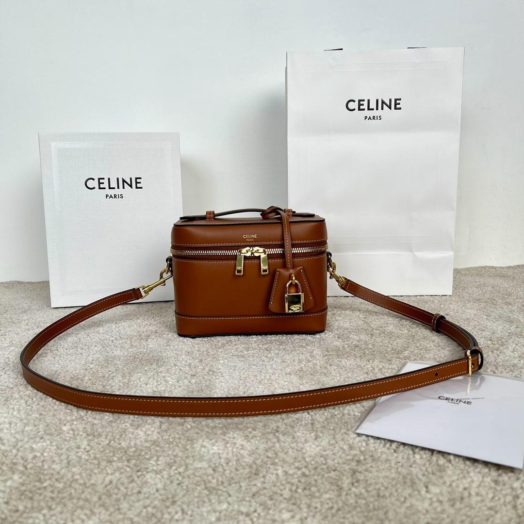 Celine: Cowhide leather vanity case, dimensions 18 x 12 x 18 cm, made of cowhide leather with a gold-plated lining. Features handles, shoulder strap, and crossbody bag with double zip closures. Includes one m