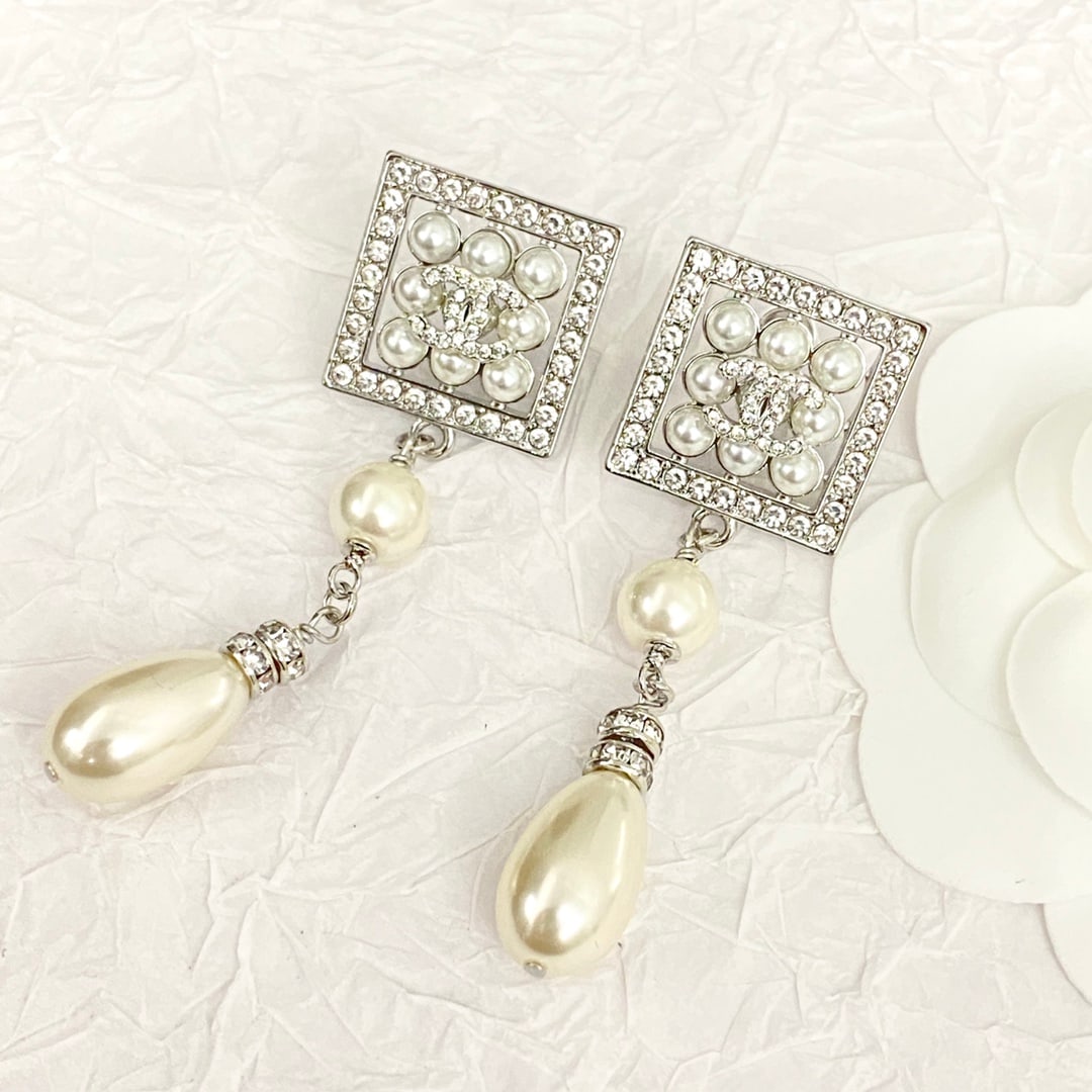 Chanel openwork square pendant earrings: Chanel openwork square pendant earrings, adorned with crystal edges and pearls, feature a hollow design with tassels and rhinestones. These pearls symbolize nobility and elegance, exuding a