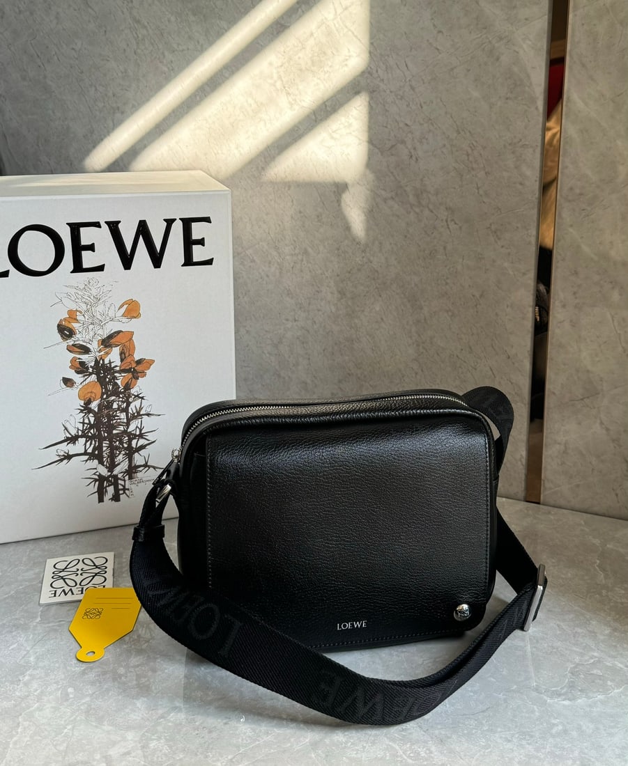 LOEWE: The LOEWE Pebble messenger bag is crafted from supple grained cowhide leather and features an adjustable LOEWE webbing shoulder strap for enhanced comfort. A versatile accessory for everyday