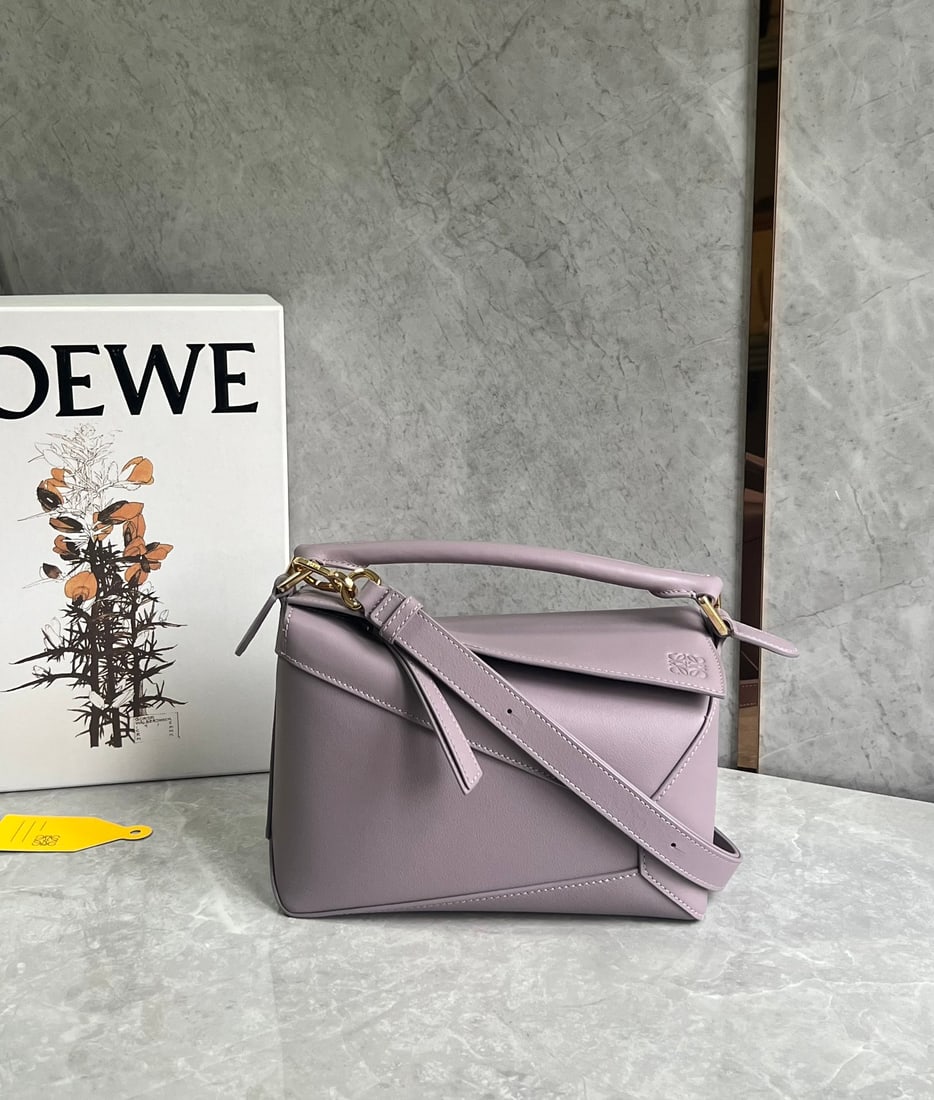 LOEWE: LOEWE Premium Taro Purple Puzzle Bag is made of calfskin, with a sand-colored patchwork design throughout. It's lightweight yet has a surprisingly large capacity, making it practical, versatile, and