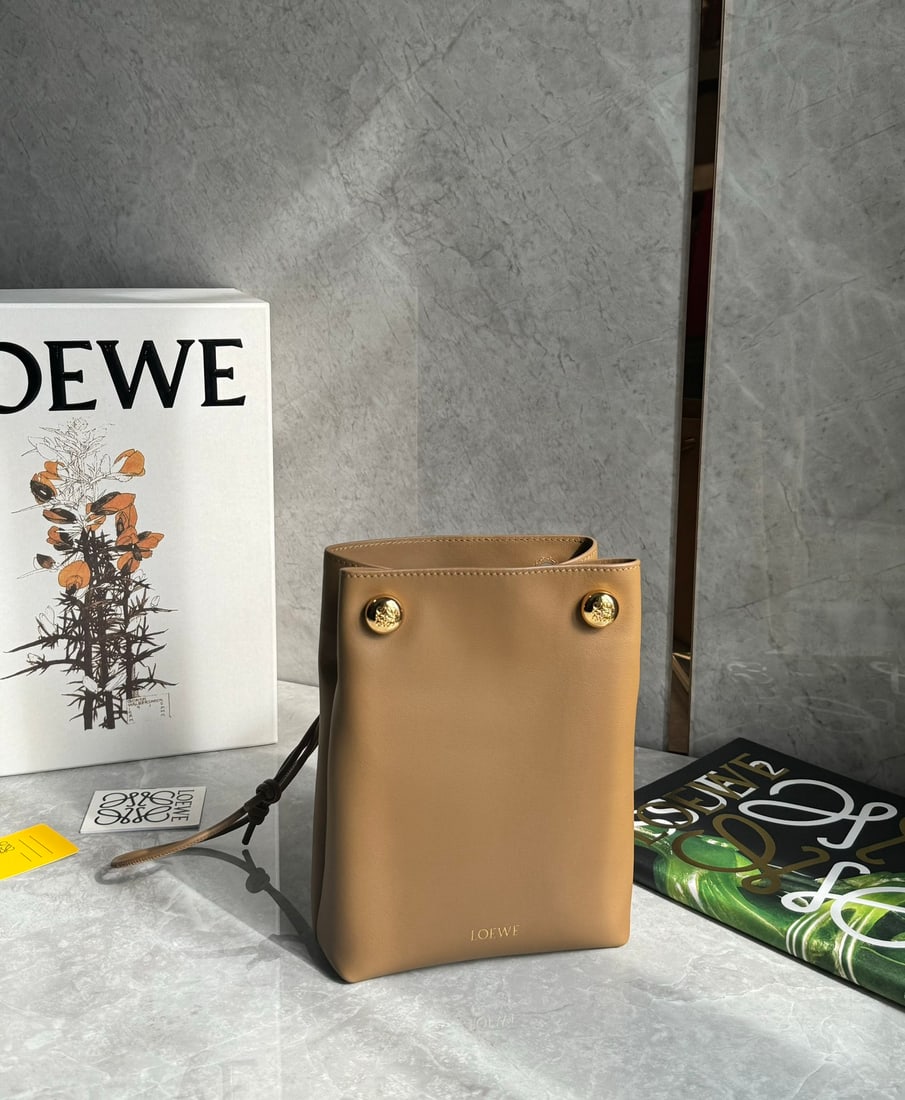 LOEWE: LOEWE Pebble Pouch: Small in size but surprisingly spacious, this bag can be worn under the arm or crossbody! Made of smooth cowhide leather, this foldable pouch features an adjustable tubular