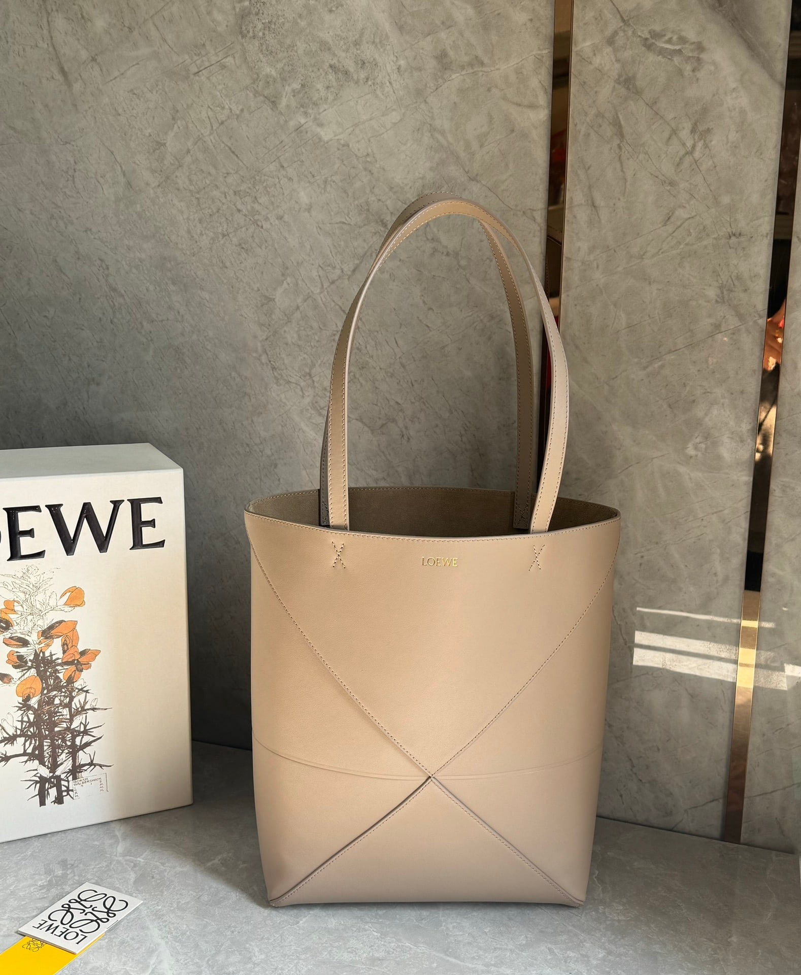 LOEWE: The LOEWE Puzzle Fold Tote bag is crafted entirely from Nappa calfskin. Inspired by origami, the Puzzle Fold Tote boasts clean lines and an understated elegance. It's incredibly soft, spacious, and it