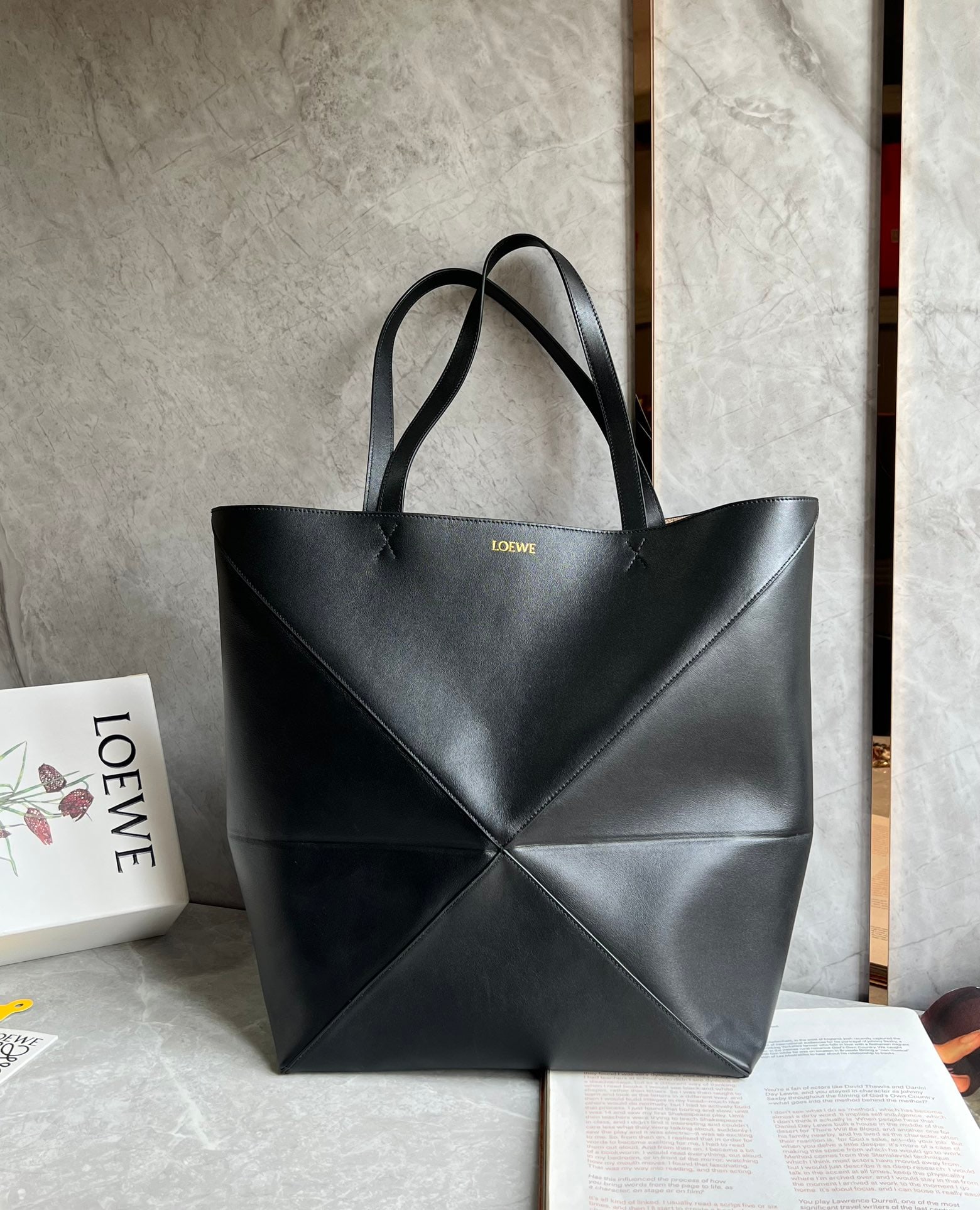 LOEWE: The LOEWE Puzzle Fold Tote is crafted entirely from Nappa calfskin. Inspired by origami, the Puzzle Fold Tote boasts clean lines and an understated elegance. It's incredibly soft, spacious, and its mo