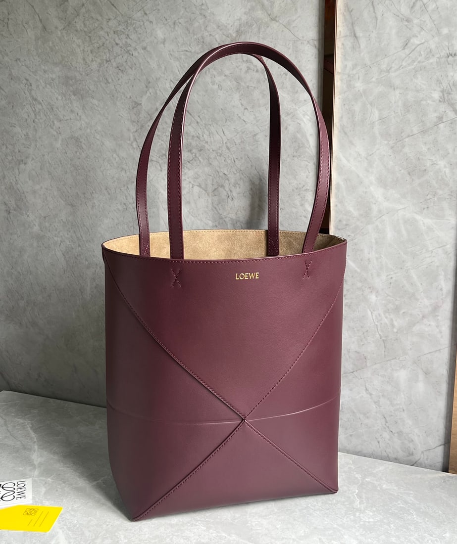 LOEWE: The LOEWE Puzzle Fold Tote bag is crafted entirely from Nappa calfskin. Inspired by origami, the Puzzle Fold Tote boasts clean lines and an understated elegance. It's incredibly soft, spacious, and it
