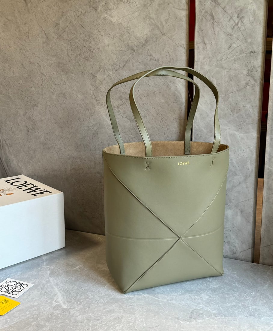 LOEWE: The LOEWE Puzzle Fold Tote bag is crafted entirely from Nappa calfskin. Inspired by origami, the Puzzle Fold Tote boasts clean lines and an understated elegance. It's incredibly soft, spacious, and it