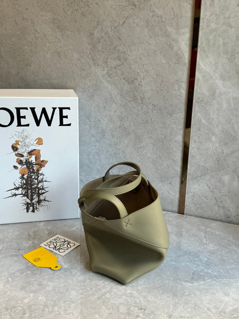 LOEWE: The LOEWE Puzzle Fold Tote bag is crafted entirely from Nappa calfskin. Inspired by origami, the Puzzle Fold Tote boasts clean lines and an understated elegance. It's incredibly soft and spacious, wit