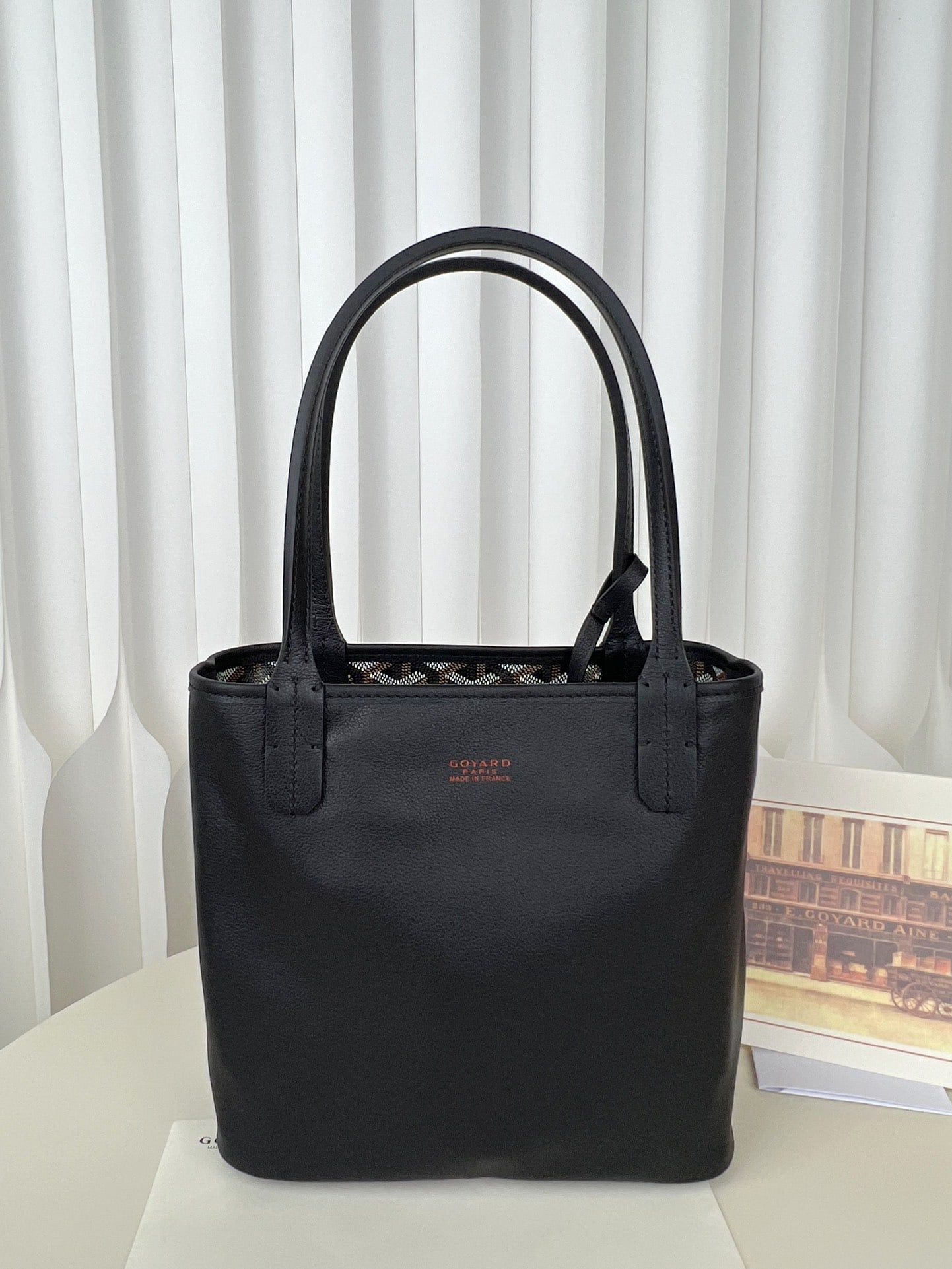 Goyard Tote Mini Anjou: The Goyard TOTE MINI ANJOU is a low-key yet stylish reversible mini tote bag crafted from Italian calfskin. The leather is incredibly soft and supple to the touch. The monogram print paired with solid
