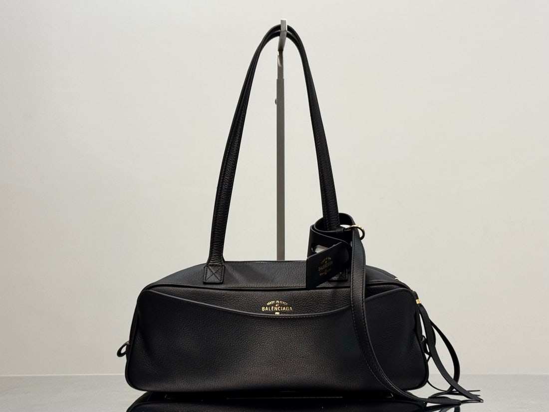 Balenciaga Carrie Bowling: The Balenciaga Carrie Bowling bag boasts a unique, curved shape with lines as fluid as musical notes, making it instantly recognizable as a Balenciaga. Its distinctive charm is undeniable; the double