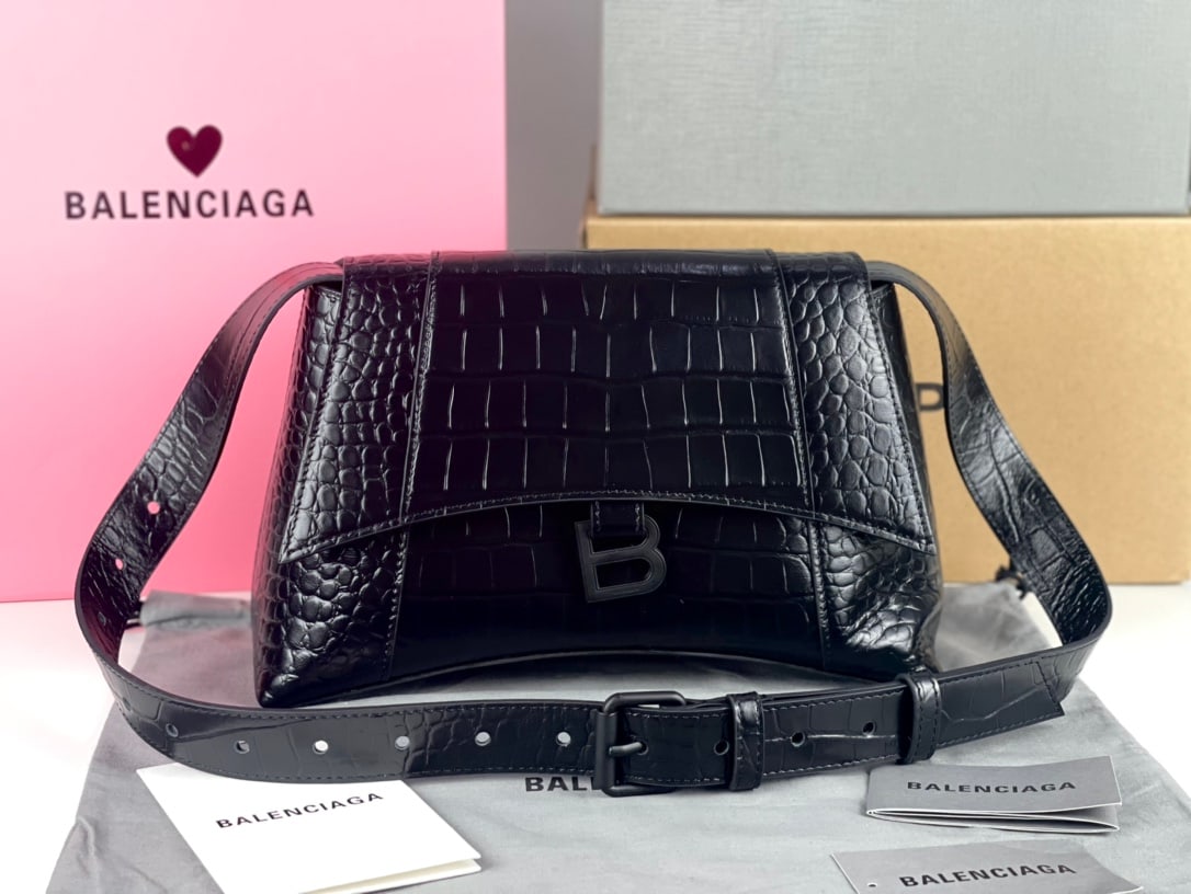 Balenciaga Hourglass: The Balenciaga Hourglass bag in black with the iconic crocodile design is highly recognizable and instantly catches the eye. Its smooth, flat surface and crescent-shaped design, topped with a metal B-