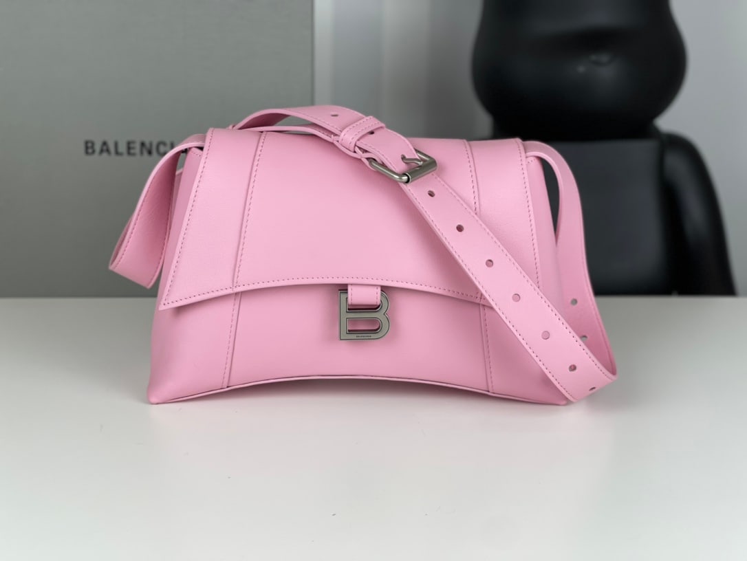 Balenciaga Hourglass: The Balenciaga Hourglass bag with its distinctive, iconic curved shape and smooth, flat surface, featuring a crescent-shaped design and a metal B-shaped pull tab, exudes sophistication. (29 x 10 x 18 
