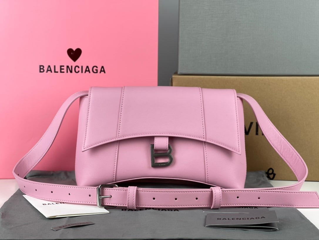 Balenciaga Hourglass: The Balenciaga Hourglass bag in a simple pink twill pattern boasts a unique and iconic curved shape that is instantly recognizable and eye-catching. Its smooth, flat surface presents a crescent shape,