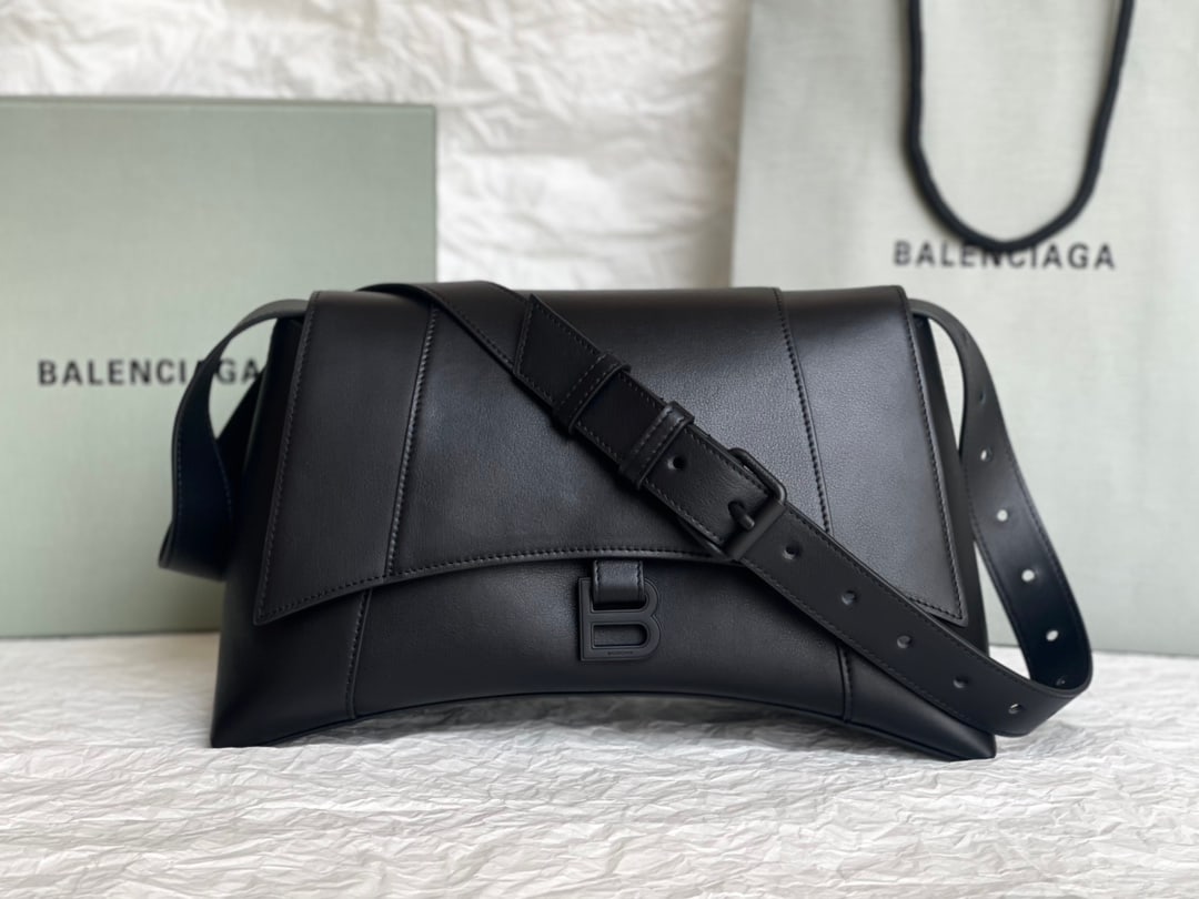 Balenciaga Hourglass: The Balenciaga Hourglass bag in a simple pink twill pattern boasts a unique and iconic curved shape that is instantly recognizable and eye-catching. Its smooth, flat surface presents a crescent shape,