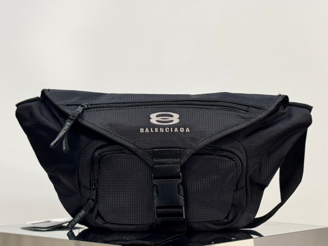 Balenciaga Unity: The Balenciaga Unity Balenciaga nylon waist bag features a Unity sports icon print on the front, matte black metal hardware, a flap closure, an adjustable shoulder strap, and multiple zippered pockets