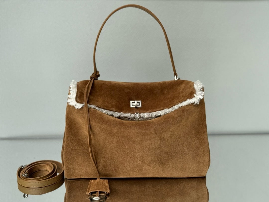 Balenciaga Rodeo Bag: The Balenciaga Rodeo Bag in dark brown suede is a must-mention for Fall/Winter. Popular throughout 2024, the Rodeo bag pioneered a new style and was extremely popular among fashionistas. Its relaxed,