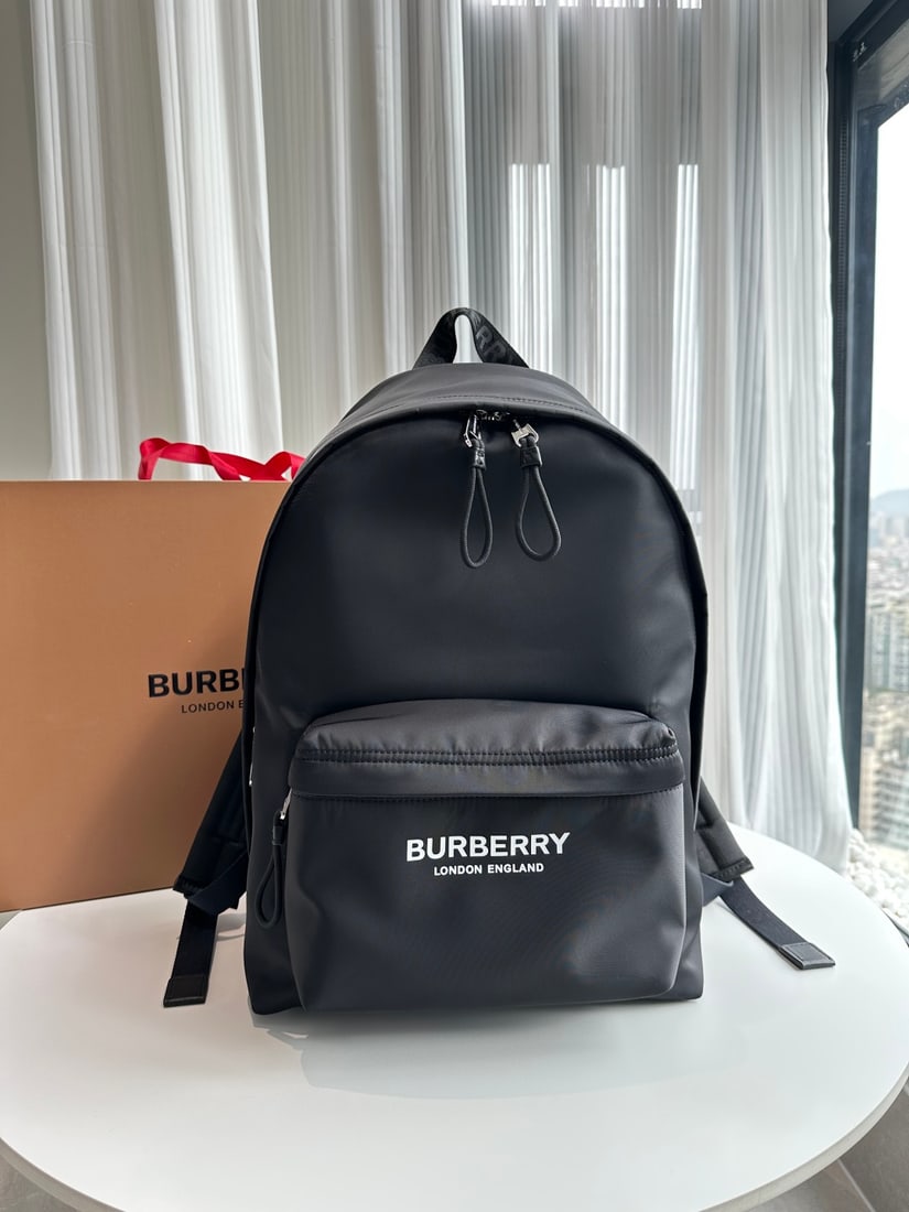 Burberry backpack: Burberry nylon backpack featuring a refreshed brand logo, smooth leather trim, and a shoulder strap adorned with a Burberry monogram jacquard logo. 30.5 x 14.5 x 42.5cm Thank you for viewing our aucti