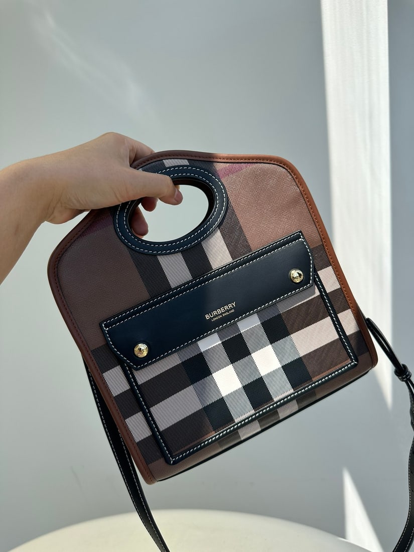 Burberry London: The Burberry London checkered canvas and leather patchwork tote bag is a timeless design inspired by classic tote bags. Made from sturdy, eco-friendly checkered canvas, it's waterproof,