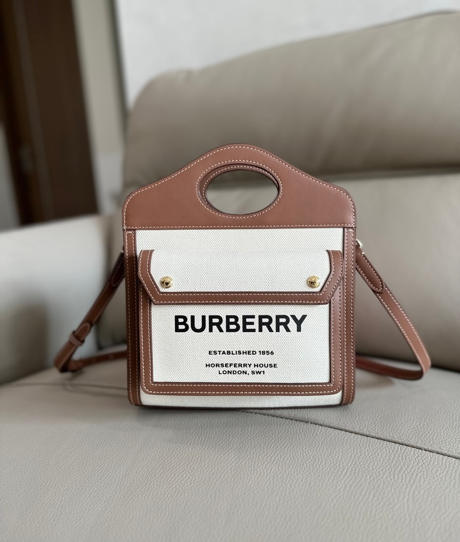 Burberry: Burberry heritage-inspired tote bag crafted from select canvas and top-stitched leather, featuring the brand's Horseferry print on the front pocket. It can be carried by the reinforced top handle or t
