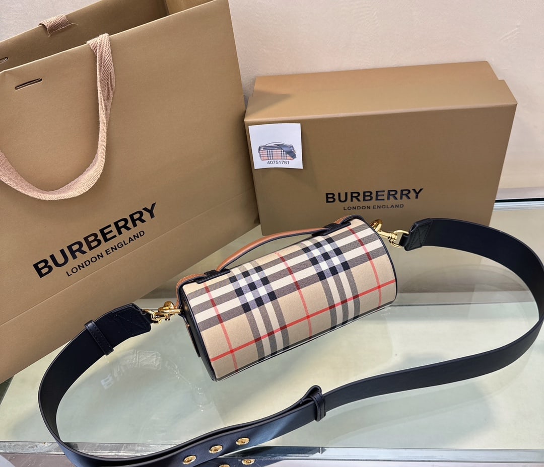 Burberry: This Burberry cylindrical mini bag is crafted from a select vintage check cotton and two-tone leather. It comes with a studded shoulder strap for carrying over the shoulder or the top handle. Dimensio