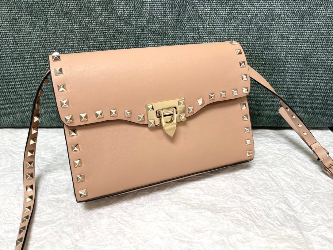 Valentino: Plain apricot Valentino messenger bag with a simple design, adjustable shoulder strap, and one interior slip pocket. Leather: Plain tumbled cowhide. Size: 22.5 x 5 x 16 cm. Thank you for viewing our