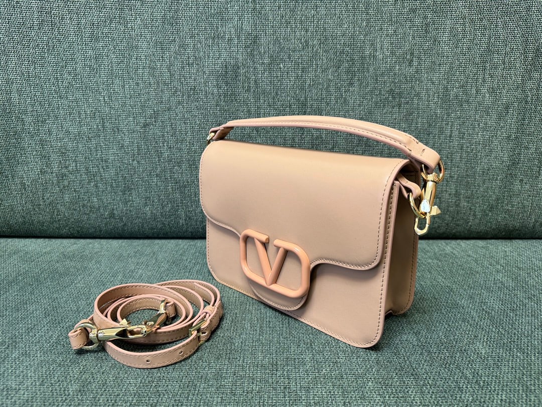 VALENTINO GARAVANI LOC0: The VALENTINO GARAVANI LOC0 valentino calfskin handbag features tonal enamel VLOGO SIGNATURE details, a detachable handle and sliding chain for versatile carrying options including hand, elbow, crossb