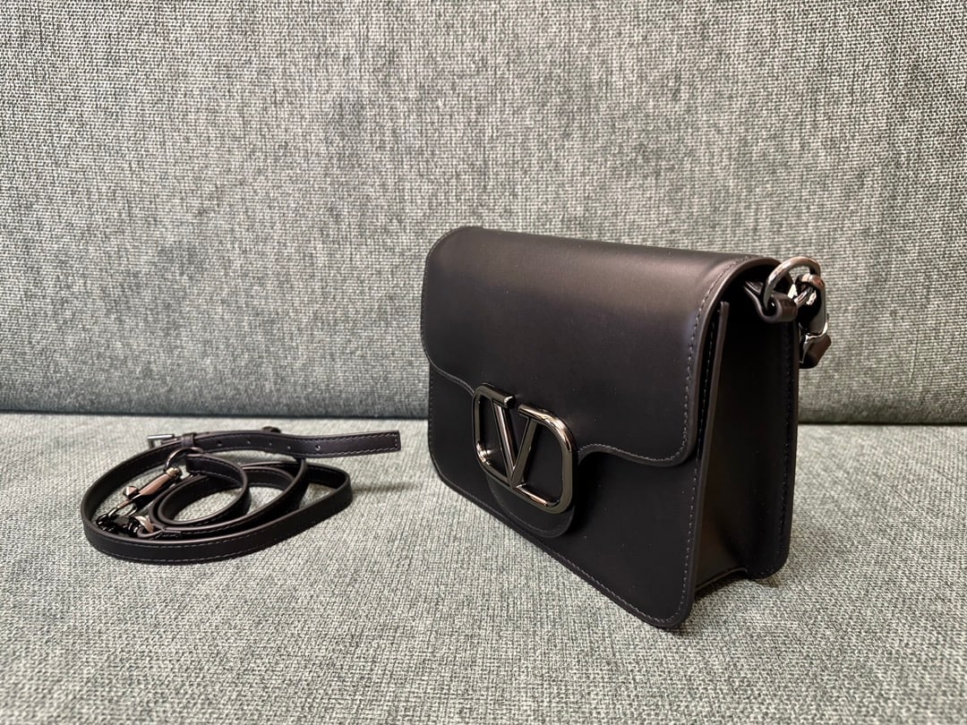 VALENTINO GARAVANI LOC0: The VALENTINO GARAVANI LOC0 valentino calfskin handbag features tonal enamel VLOGO SIGNATURE details, a detachable handle and sliding chain for versatile carrying options including hand, elbow, crossb