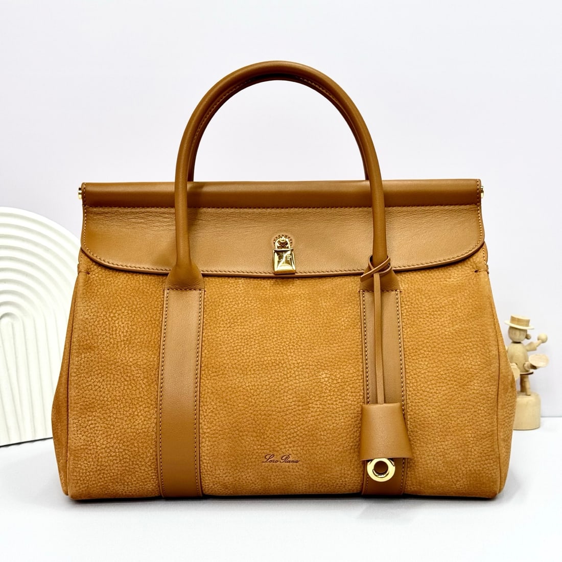 Loropiana Loro piana Loom L32 Handbag: The Loro Piana Loom L32 tote bag is crafted from premium calfskin leather with a suede lining, offering a unique and lightweight feel. It features a delicate padlock that can be opened, exuding a casu