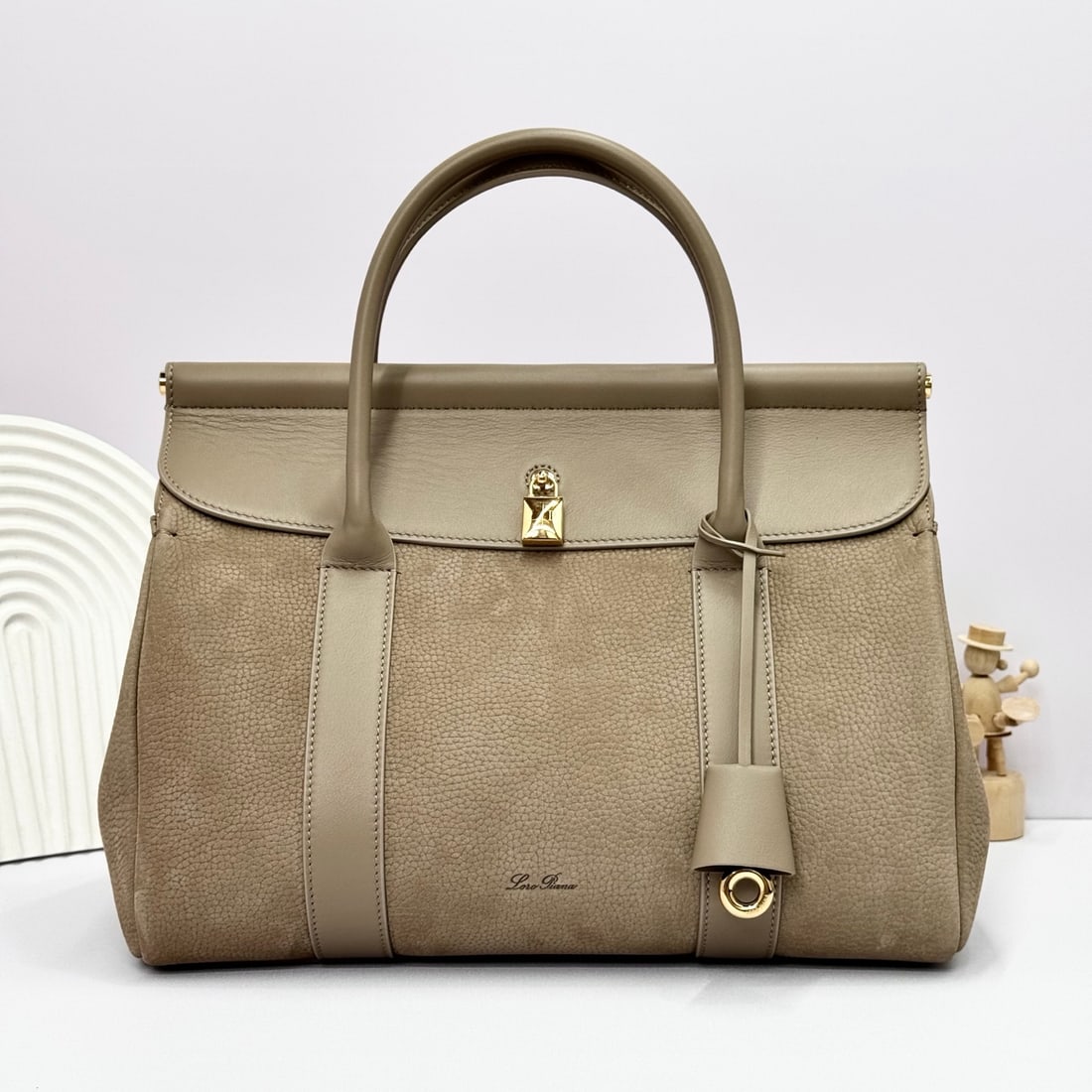 Loropiana Loro piana Loom L32 Handbag: The Loro Piana Loom L32 tote bag is crafted from distinctive calfskin leather with a suede lining, offering a unique and lightweight feel. It features a delicate padlock that can be opened, exuding a 