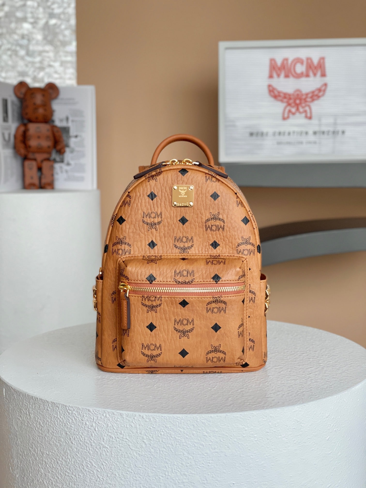 MCM STARK VISETOS mini studded backpack: MCM STARK VISETOS mini studded backpack in classic cognac. This miniature version of the classic MCM design uses the iconic Visetos coated canvas with a luxurious faux leather lining and studded
