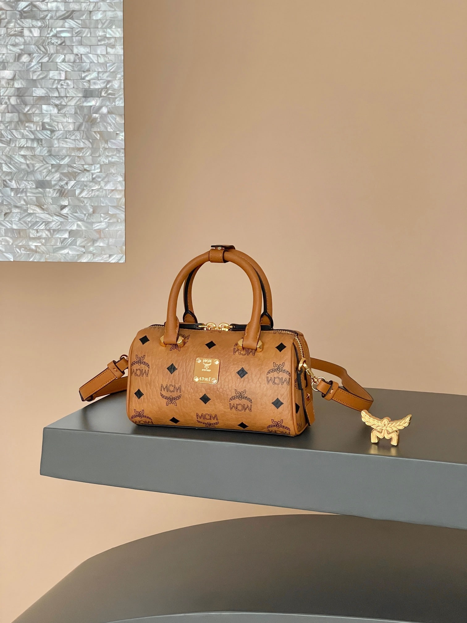 MCM AREN ESSENTIAL ORIGINAL MINI Newly Upgraded Boston Bag: The newly upgraded MCM AREN ESSENTIAL ORIGINAL MINI Boston bag in classic cognac can be worn as a shoulder bag or crossbody. This mini Boston bag offers a fresh interpretation of classic style,