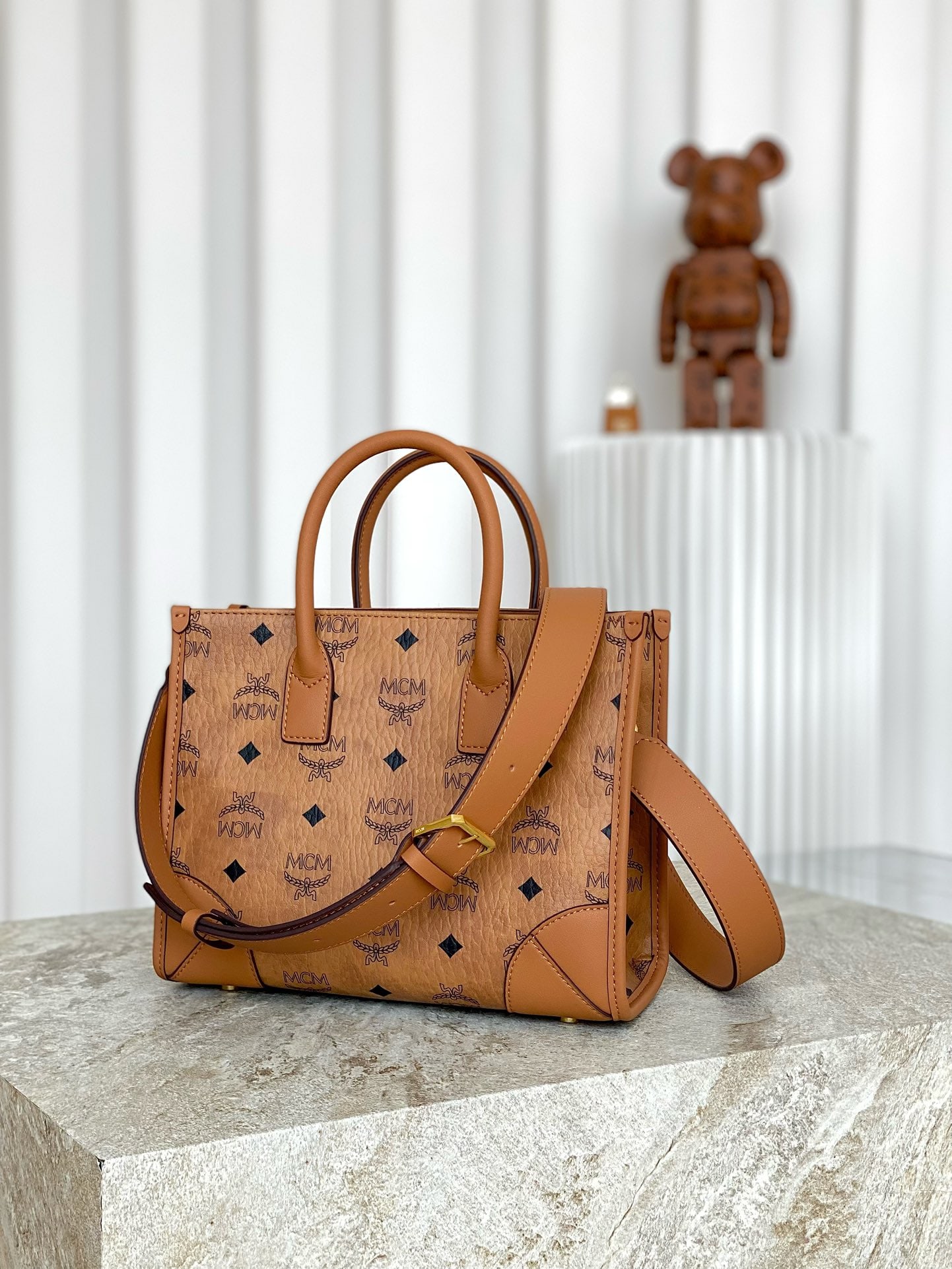 MCM MUNCHEN VISETOS Handbag/Crossbody Bag: The MCM MUNCHEN VISETOS Tote/Crossbody Bag with All-Over Monogram Print: This small Munchen tote bag embodies the timeless spirit of the Bavarian capital. Adhering to the principle of form following