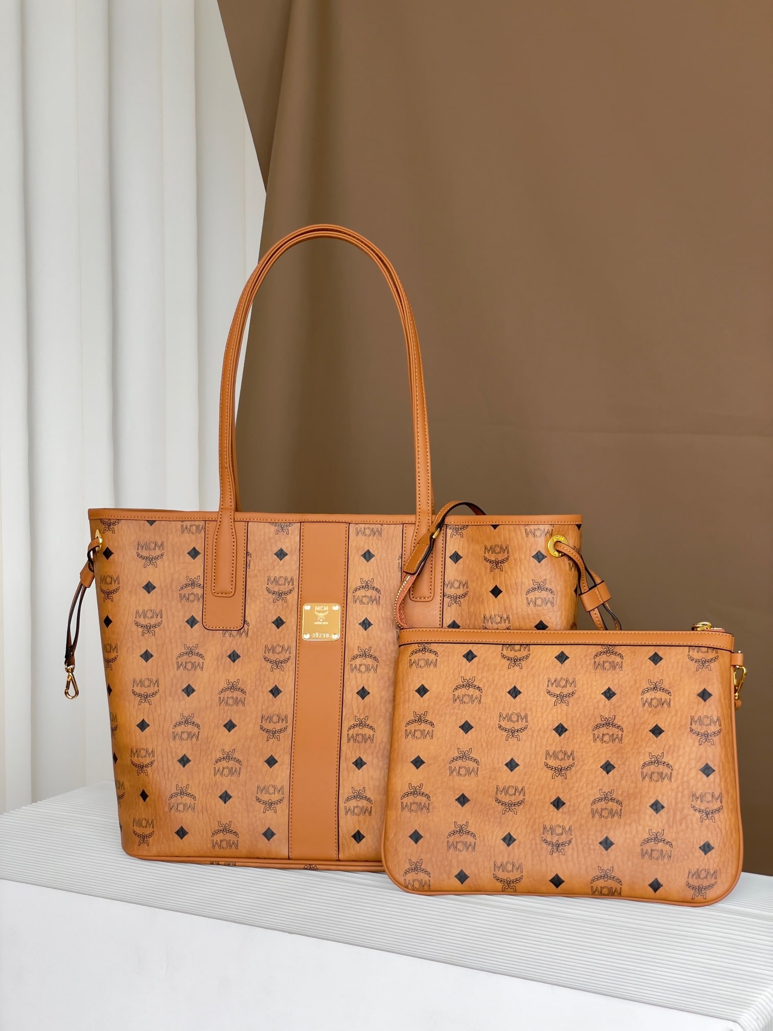 MCM LIZ VISETOS MINI Medium Reversible Shopping Bag (Mother Bag): The MCM LIZ VISETOS MINI Medium Reversible Shopping Bag, in classic cognac, combines two iconic looks into one everyday piece. Crafted from Visetos and Nappa leather, this medium-sized Liz shopping