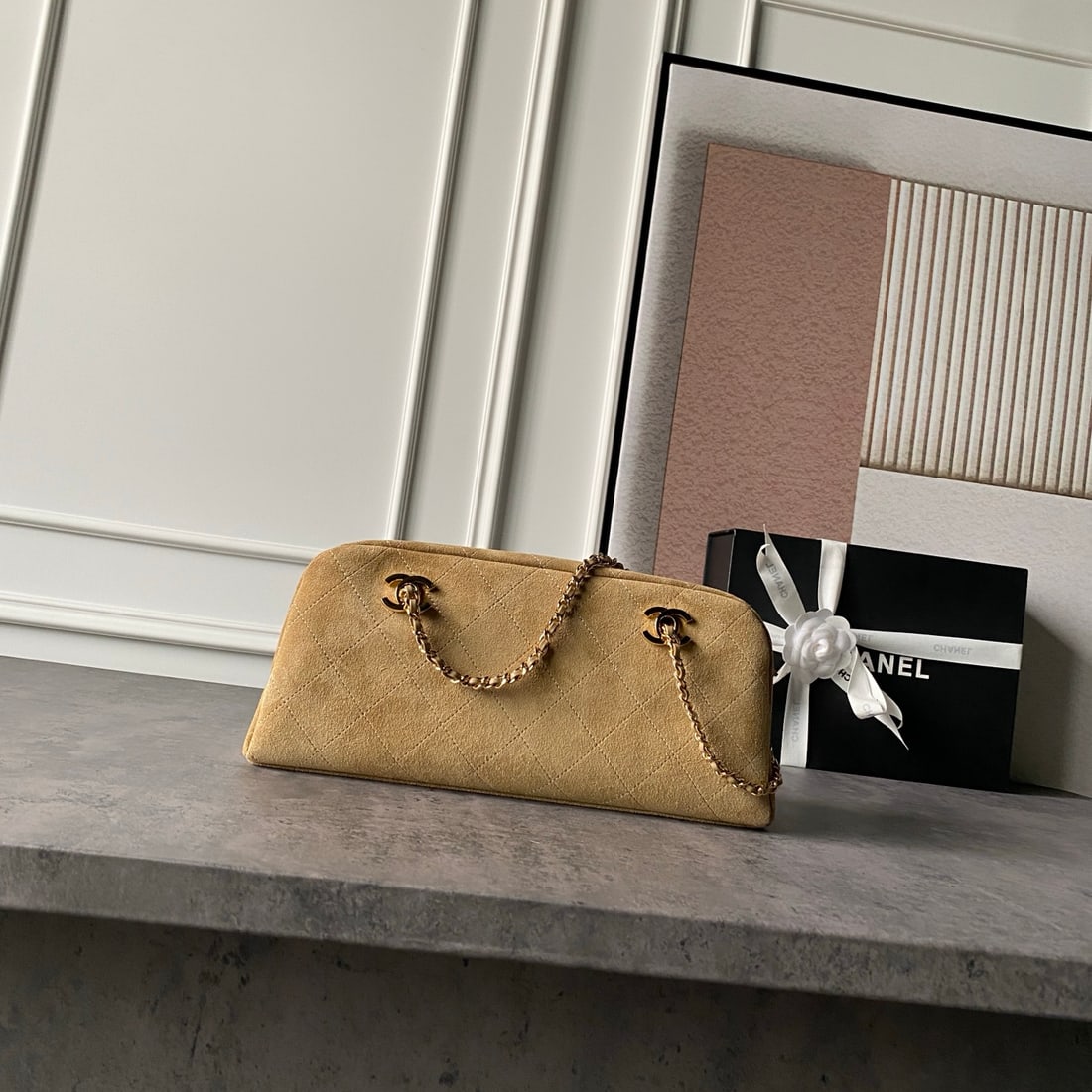 CHANEL Limited Edition Suede Bowling Ball: CHANEL Limited Edition Suede Bowling Bag: Vintage suede texture, classic quilted diamond pattern, matte suede finish, understated yet layered, light gold hardware paired with a metal chain. The elonga