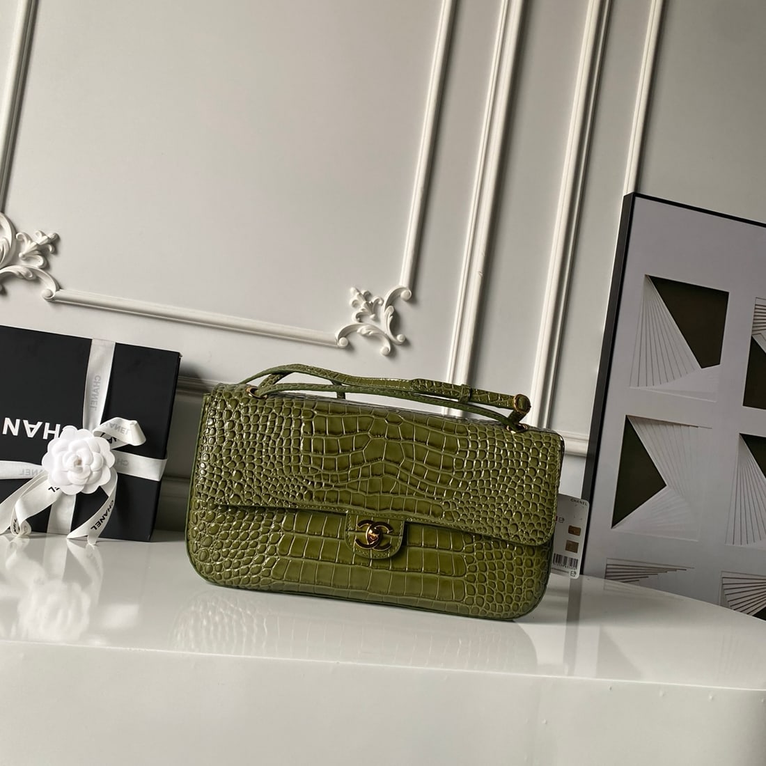 CHANEL Maxi Airport Bag: This CHANEL Maxi airport bag features a classic vintage style with a glossy crocodile-embossed pattern and a retro bright gold finish. The classic double C buckle exudes understated elegance. The