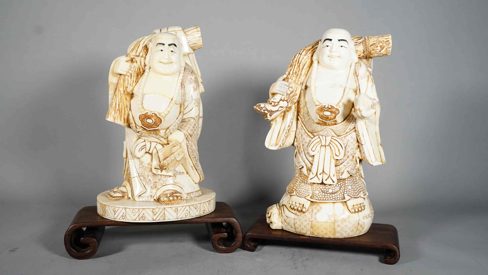Two Large Japanese Vintage Bone Carved Happy Buddhas Carrying Money Bag: Two Large Japanese Vintage Bone Carved Happy Buddhas Carrying Money Bag. Tall Buddha: 10"1/2H, 6"W, 4"D; Short Buddha (with Artis Sign): 9"3/4H, 6"1/2L, 5"3/4D