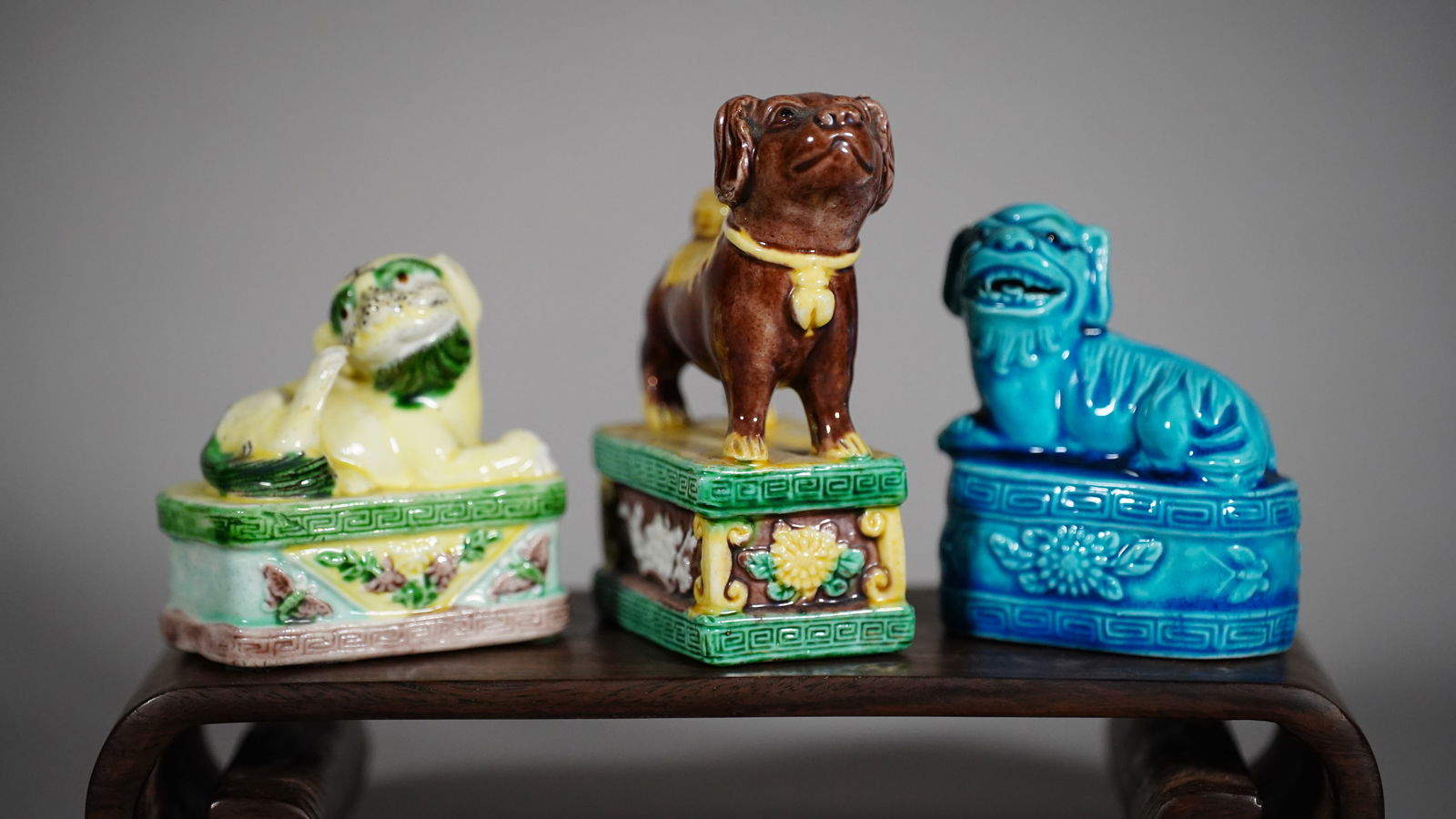 Three Charming Chinese Antique Porcelain Foo Dogs: Three Charming Chinese Antique Porcelain Foo Dogs Standing & Lying on High Floral Medallion Bases, Glazed in Yellow, Green, Brown & Blue. Size: 2"1/2L x 1"3/4W x 3"3/4H (Blue); 2"3/4L x 1"3/4W x 3"H;