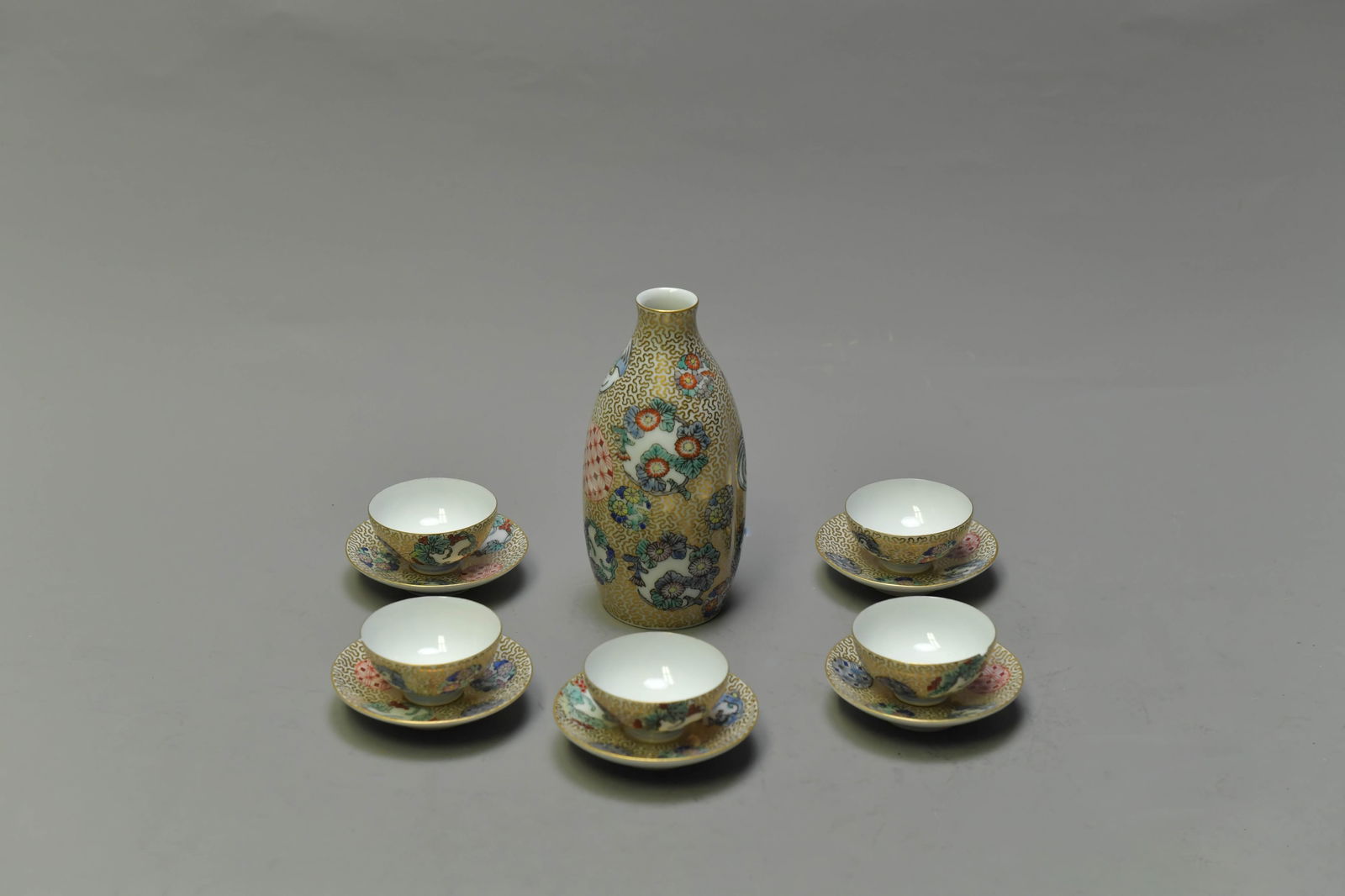 Lot of 11 Japanese Imari Porcelain Sake Vessel Set: Lot of 11 Japanese Imari Porcelain Sake Vessel Set. Vessel 5"Tall, Cup 2"W x 1"H (5pcs), Small coaster 2"3/4W; Good condition, excepted one cup has small chip at the rim. (Stand Not Included).