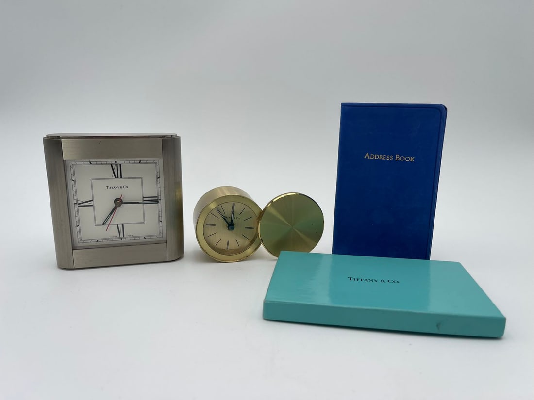 2 Vintage Tiffany & Co. Table Clocks Swiss Made & A Pocket Address Book: 2 Vintage Tiffany & Co. Table Clocks Swiss Made & A Blue Nubuck Pocket Address Book. 1)A vintage Tiffany & Co. round gold tone clock, 2"1/4Dia, Swiss Quartz, 200570, Normal wear and tear; 2)A vintage