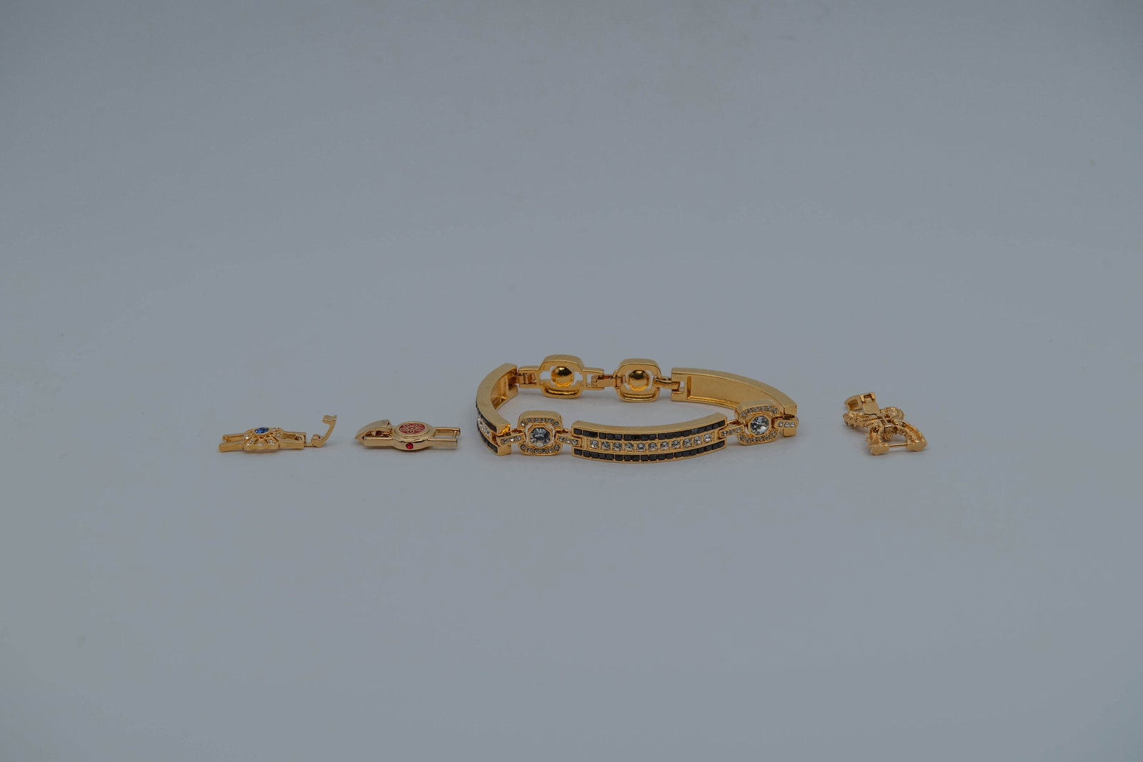 JBK Gold Tone Dramatic Costume Bracelet w/Three Extra Bracelet Clasps, CHINA: JBK Gold Tone Dramatic Costume Bracelet w/Three Extra Bracelet Clasps, CHINA. Length 8", width 1/2"; In good condition, (Stand Not Included)