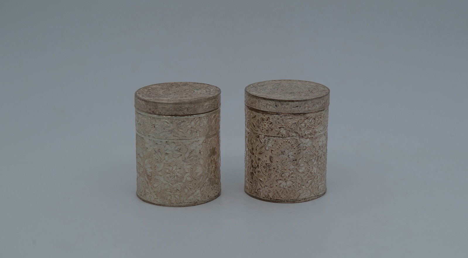 Pair of Vintage Cylindrical Tobacco Boxes w/Engraved Relief Floral Patterns: Pair of Vintage Cylindrical Tobacco/Tea Caddy Metal Boxes w/Engraved Relief Floral Patterns. 2"1/2H x 2"W; Total weight: 129.9g, In good condition