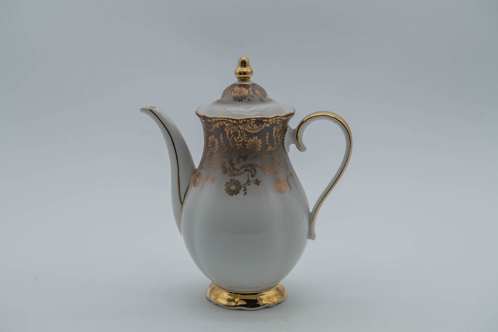 Vintage Eberthal Bavaria Porcelain Coffee/Tea Pot, West Germany: Vintage Eberthal Bavaria Porcelain Coffee/Tea Pot, West Germany. It features intricate gold detailing on the body and lid. Measures approx. 7"1/2H x 6"1/2W; In good overall condition, with a small chi