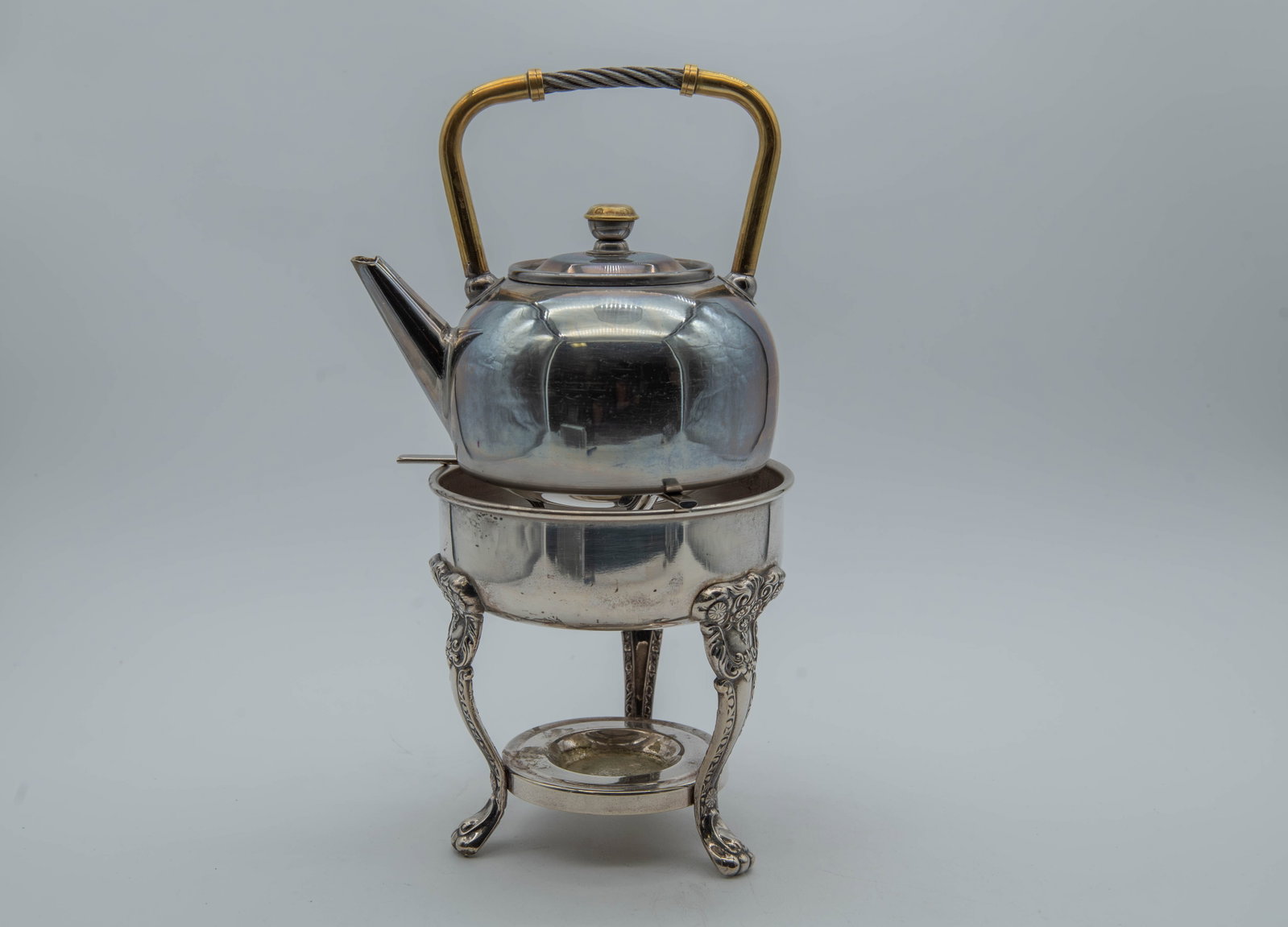 Lot of 2 Vintage Tea Pot & Warmer Burner Holder: Lot of 2 Vintage Tea Pot & Warmer Burner Holder. 1)A three-footed stand with an included warmer burner holder, 6"W x 6"1/4H; 2)VIMA teapot, Industria Argentina, Measures 7"W x 6"H, Pre-owned condition