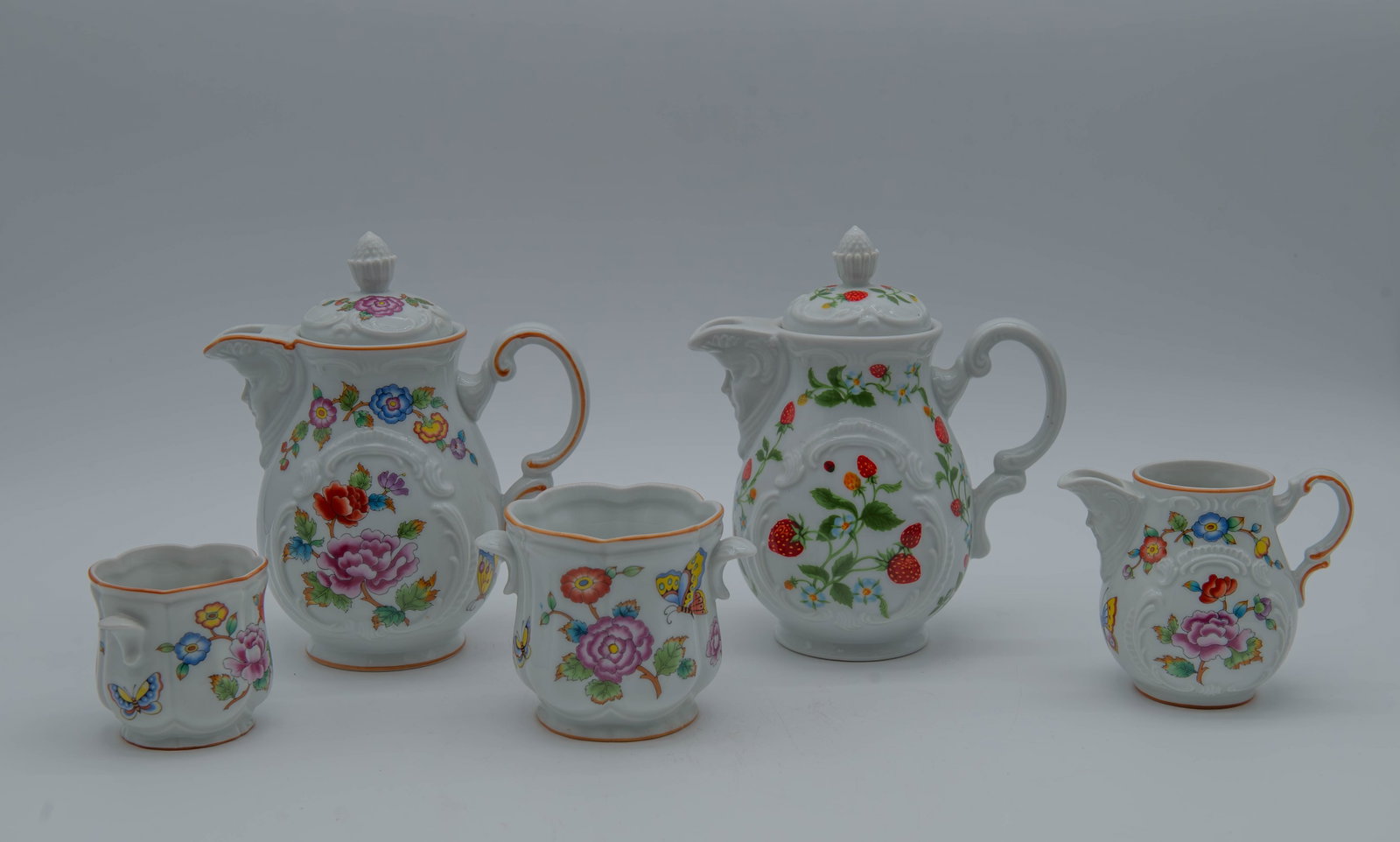 Lot of 7 Vintage Estee Lauder Chinoiserie Porcelain Set: Lot of 7 Vintage Estee Lauder Chinoiserie Porcelain Collection Set. 1)Two vanity jars with vibrant floral and butterfly pattern, and fluted rim. Measures 2"1/2H x 3"1/4W and 3"1/4H x 4"1/2W; 2)A cream