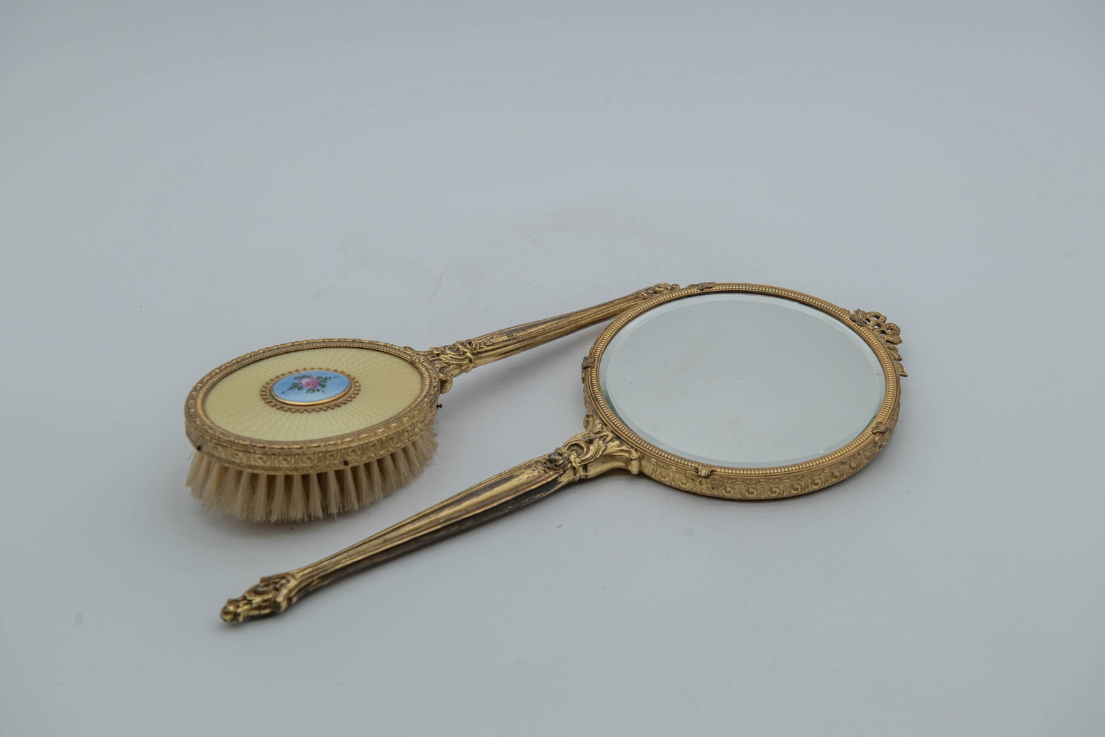 Lot of 2 Vintage Guilloche Enamel Handheld Vanity Mirror & Brush w/Gilt Brass Trim: Lot of 2 Vintage Guilloche Enamel Handheld Vanity Mirror & Brush w/Gilt Brass Trim & Floral Design. 1)Mirror size 13"L x 5"1/2W; 2)Brush size: 10"L x 3"1/2W; Overall in good condition, with normal wea
