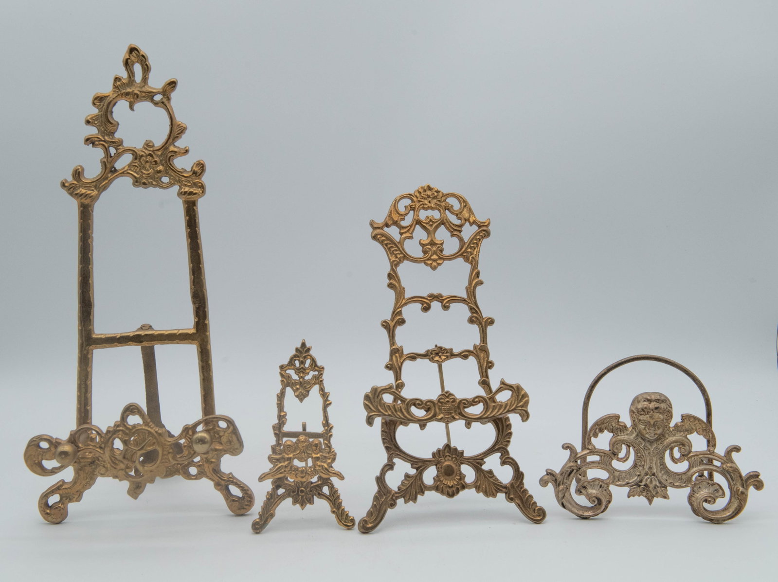 Lot of 4 Vintage Ornate Brass Metal Easels: Lot of 4 Vintage Ornate Brass Metal Easels. Measures 6"H x 3"W, 4"1/2H x 6"1/4W, 10"1/4H x 5"1/2W, 13"1/4H x 6"1/4W; In good vintage condition.